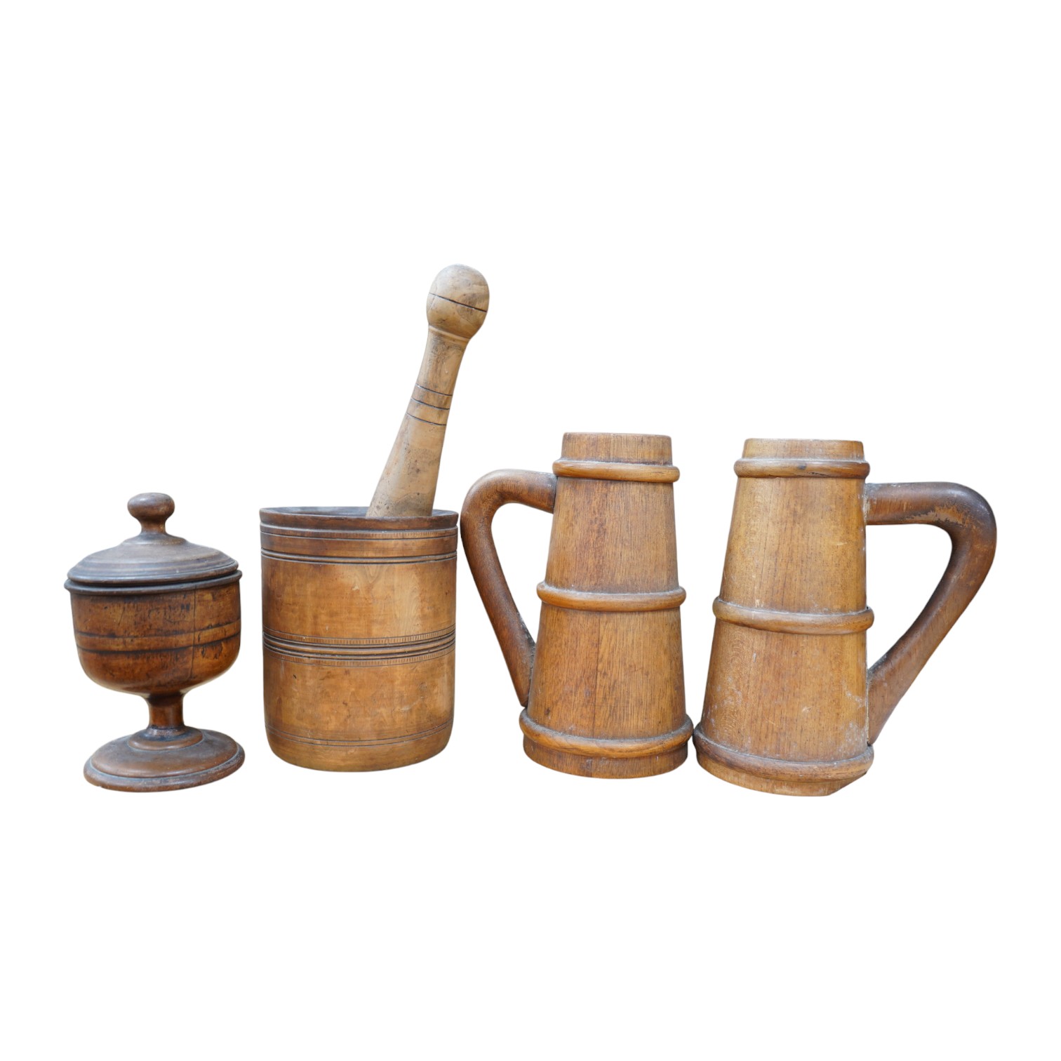 A pair of staved beech flagons, 23cm high, a wooden pestle and mortar, 17.5cm, and turned wood lidded bowl, 18cm (5). Condition - fair